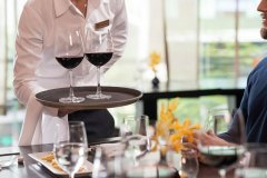 Cropped image of waiter serving drinks in a restaura